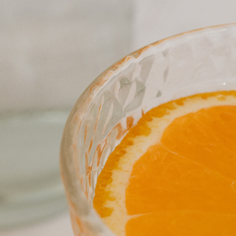 A slice of orange in a glass of water, representing hydration and electrolyte support during pregnancy and motherhood