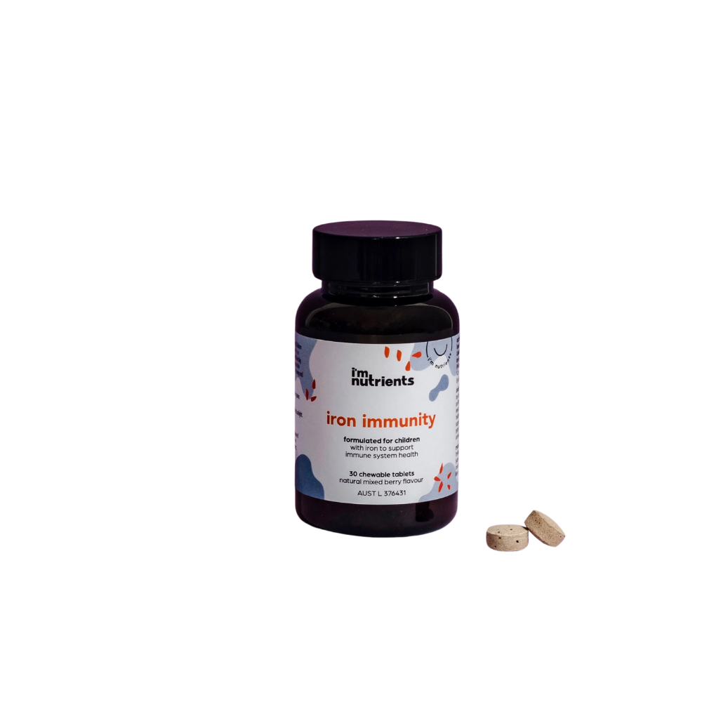 A bottle of 'I'm Nutrients Iron Immunity' for kids with a purple label, alongside two tablets with a mixed berry flavor.