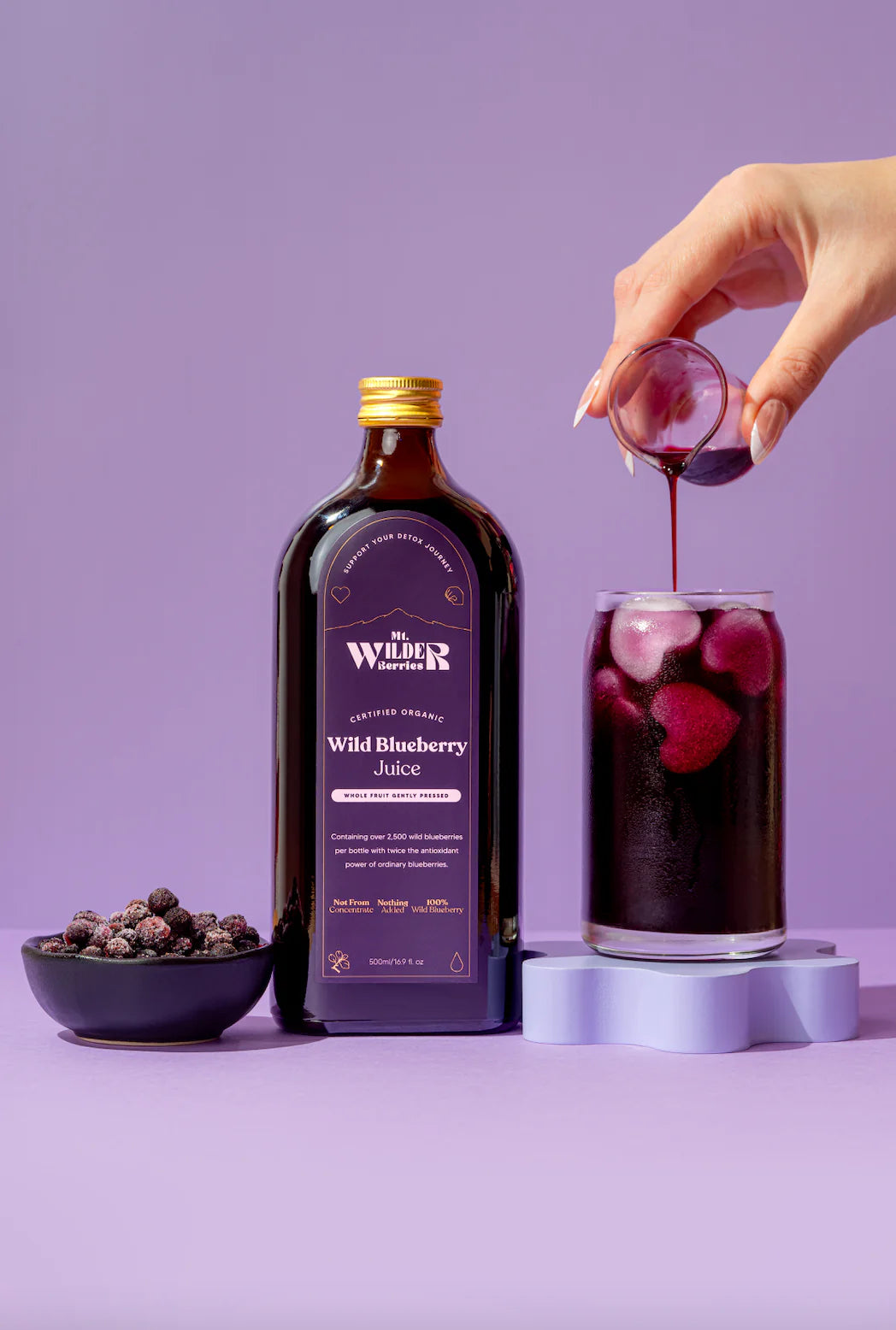 small glass of dark elderberry juice, representing a daily shot of wellness