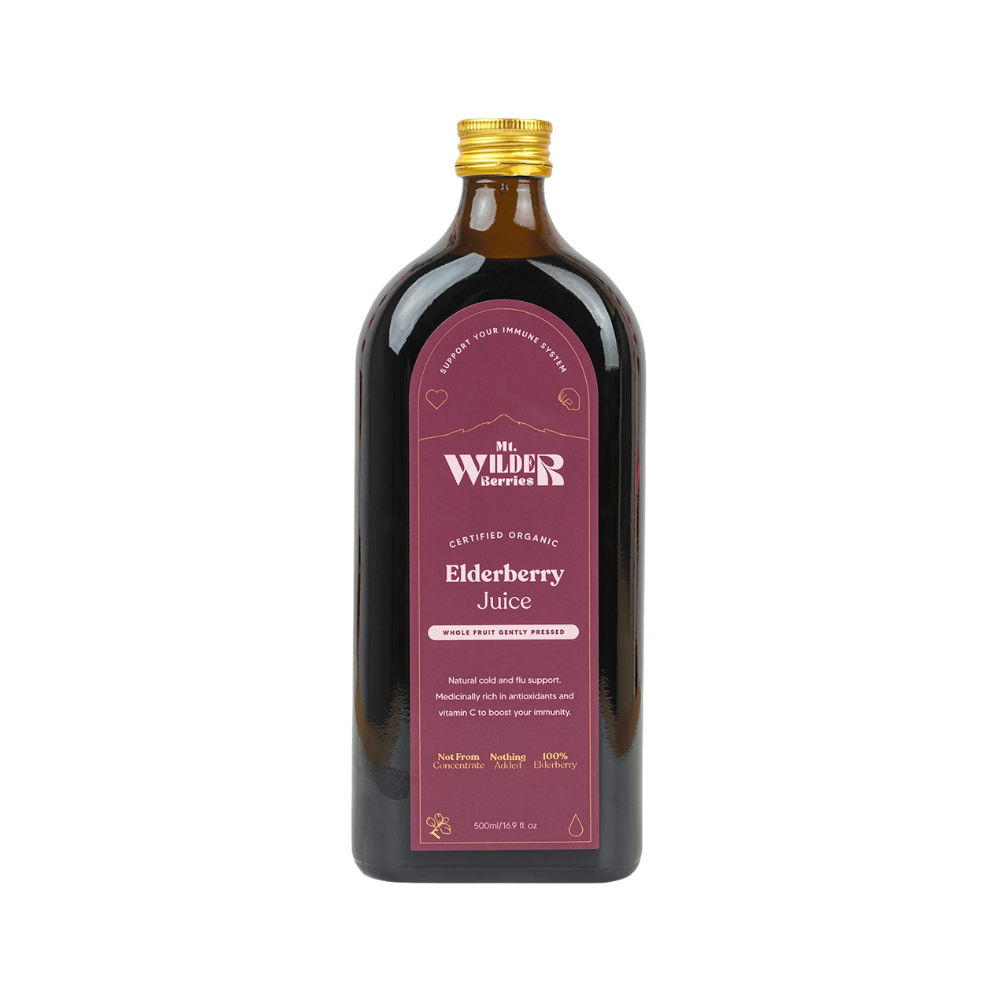 A bottle of Mt. Wilder Berries Certified Organic Elderberry Juice with a purple label, amber glass jar, and a gold cap.