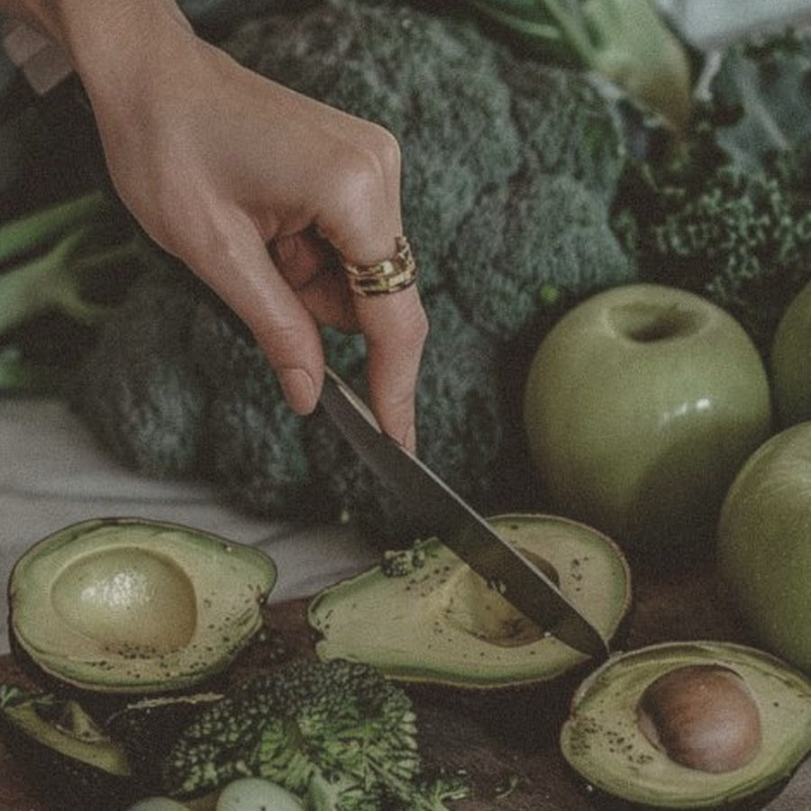 Preparing fresh greens and avocado: broccoli, kale and apples on a wooden board