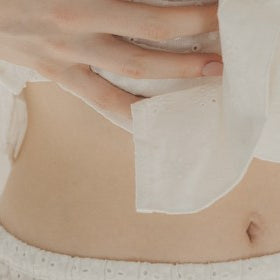 Close-up of a person wearing a white garment with a visible patch on their abdomen.