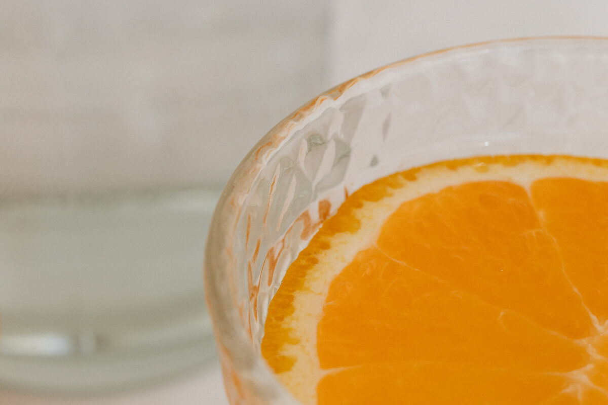 A slice of orange in a glass of water, representing hydration and electrolyte support during pregnancy and motherhood