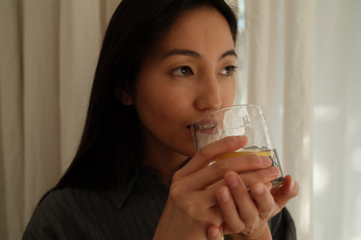 Woman drinking water with lemon from a glass