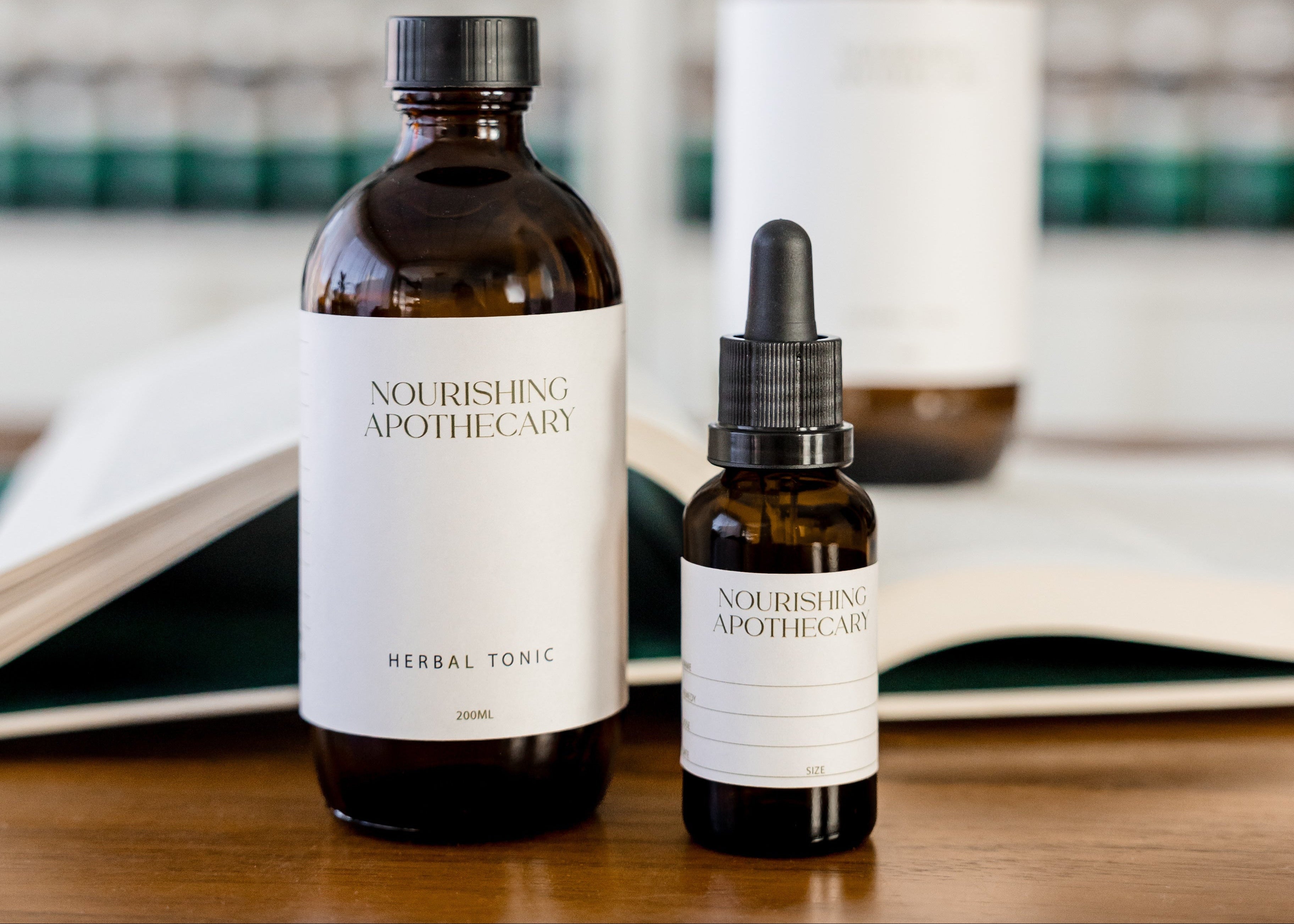 Two bottles of Nourishing Apothecary products on a wooden surface with shelves in the background.