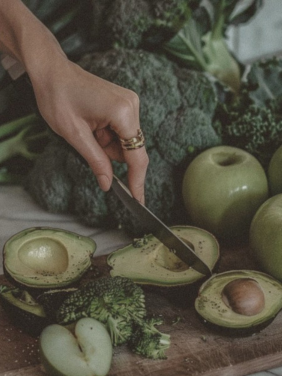 Preparing fresh greens and avocado: broccoli, kale and apples on a wooden board