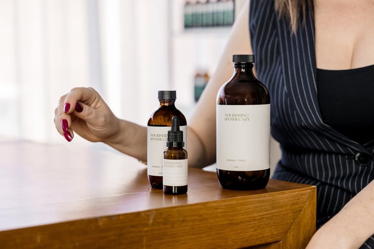 Nourishing Apothecary tonic bottles and dropper on the clinic bench